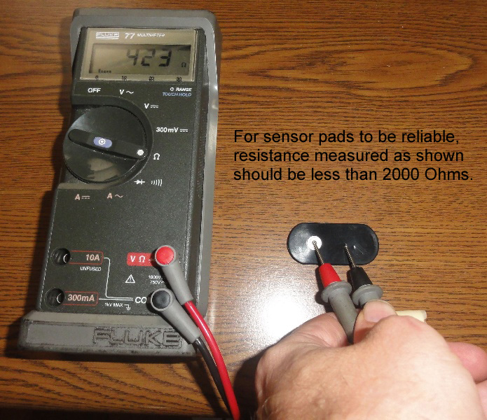 Person using multimeter to check sensor pads